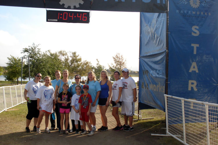 A group of people standing under a blue sign.