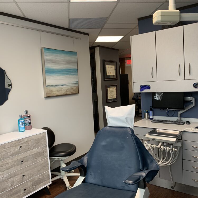 A dentist 's office with a chair and desk.